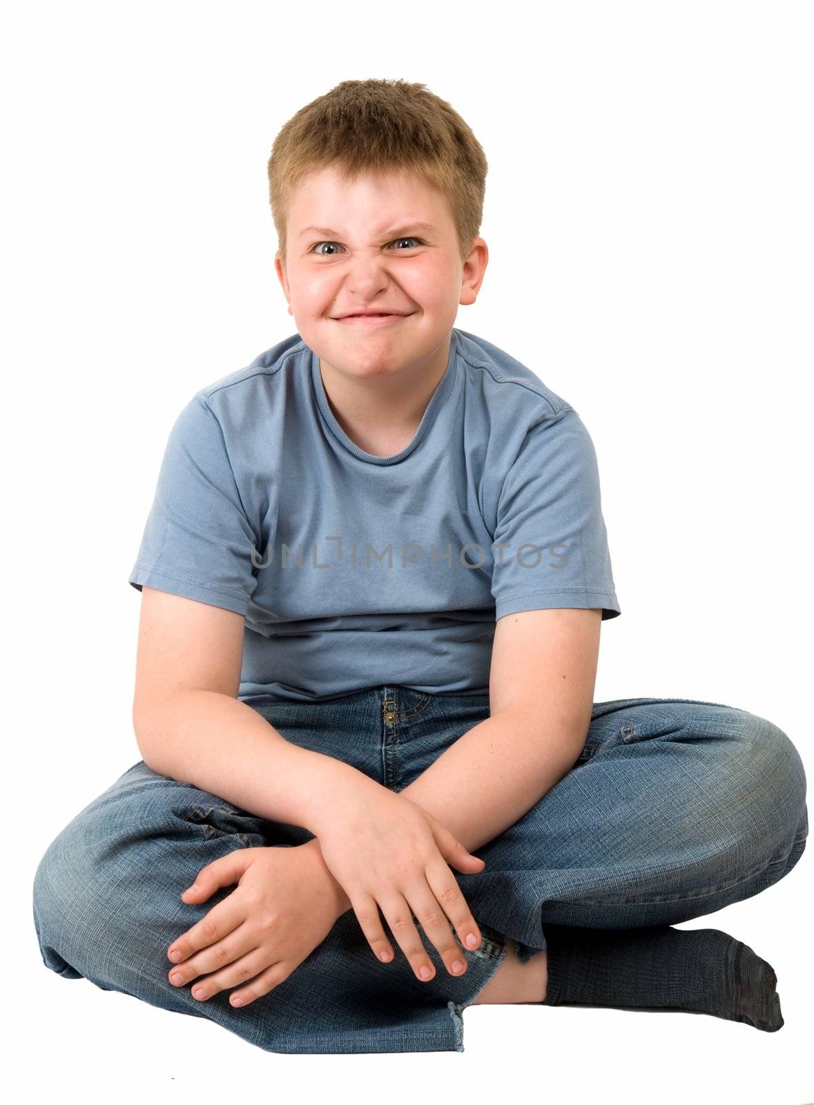 angry little boy sits on a white background