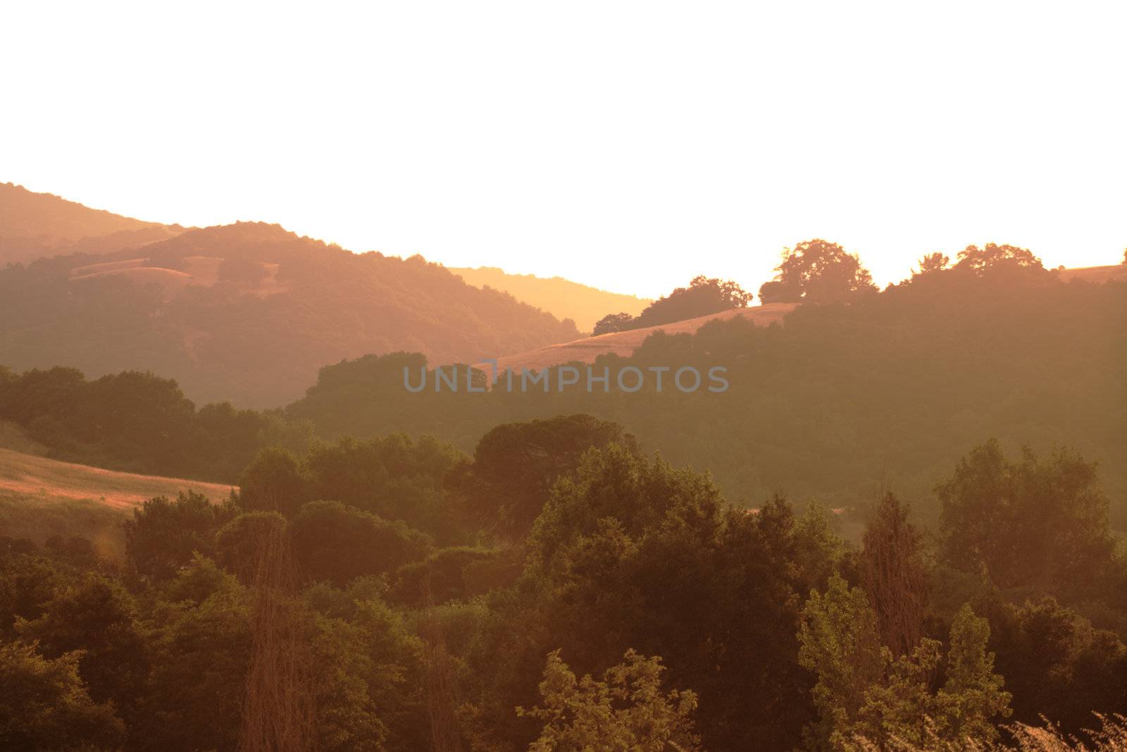 smoke from nearby fires bring a golden haze to the foothills just before sunset 