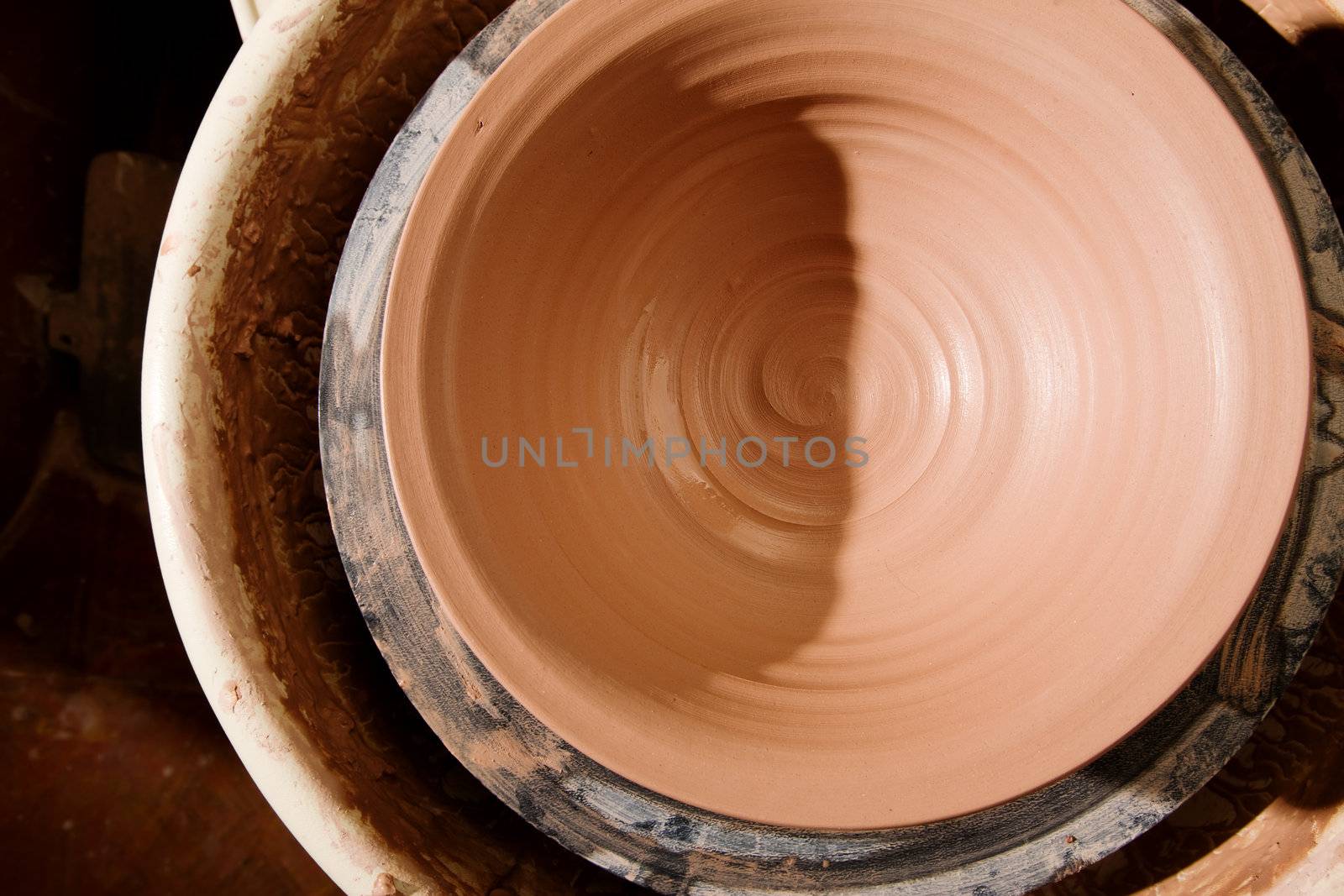 Earthenware clay bowl newly formed on potters wheel