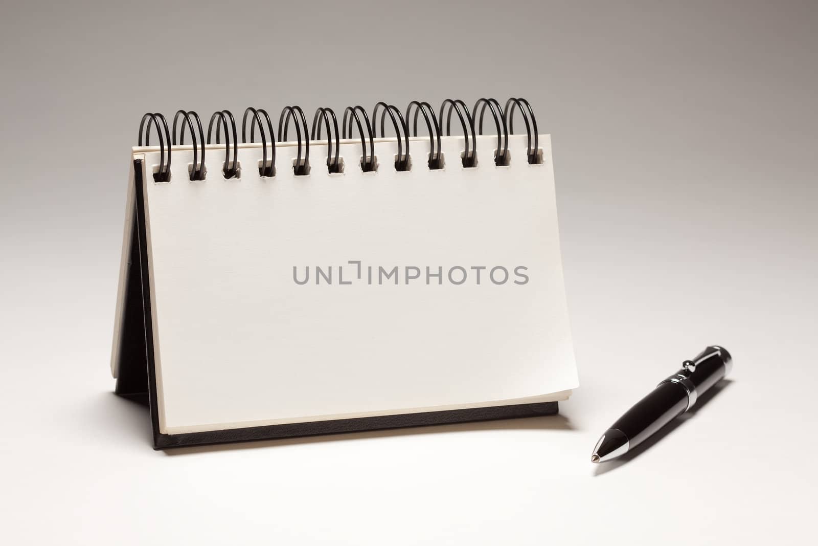 Blank Spiral Note Pad and Pen on a Gradated Background.