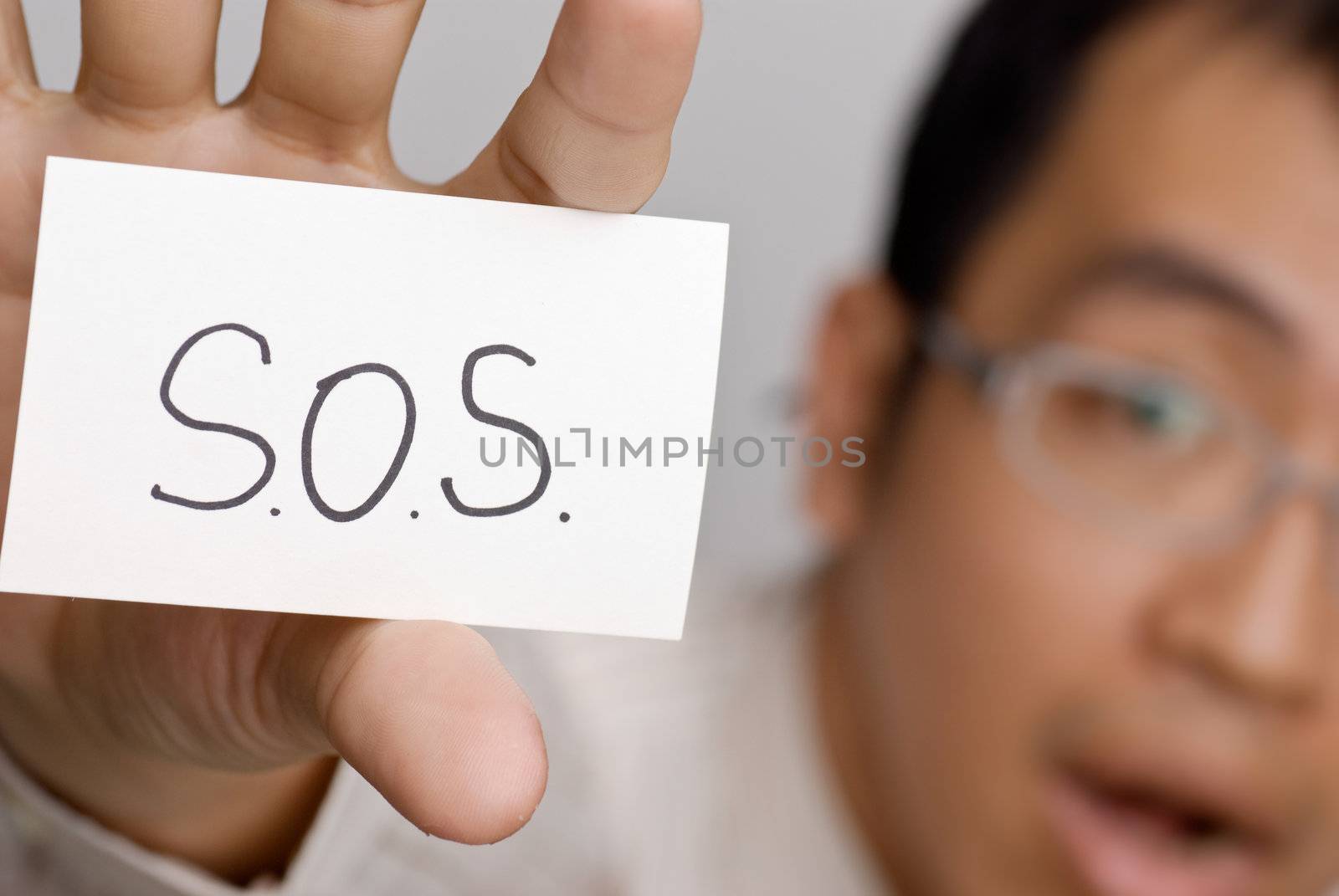 Business man need help and write SOS on white card.