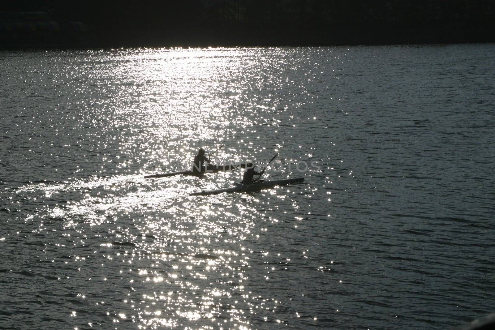 A couple kayaking, with reflection. by skutin