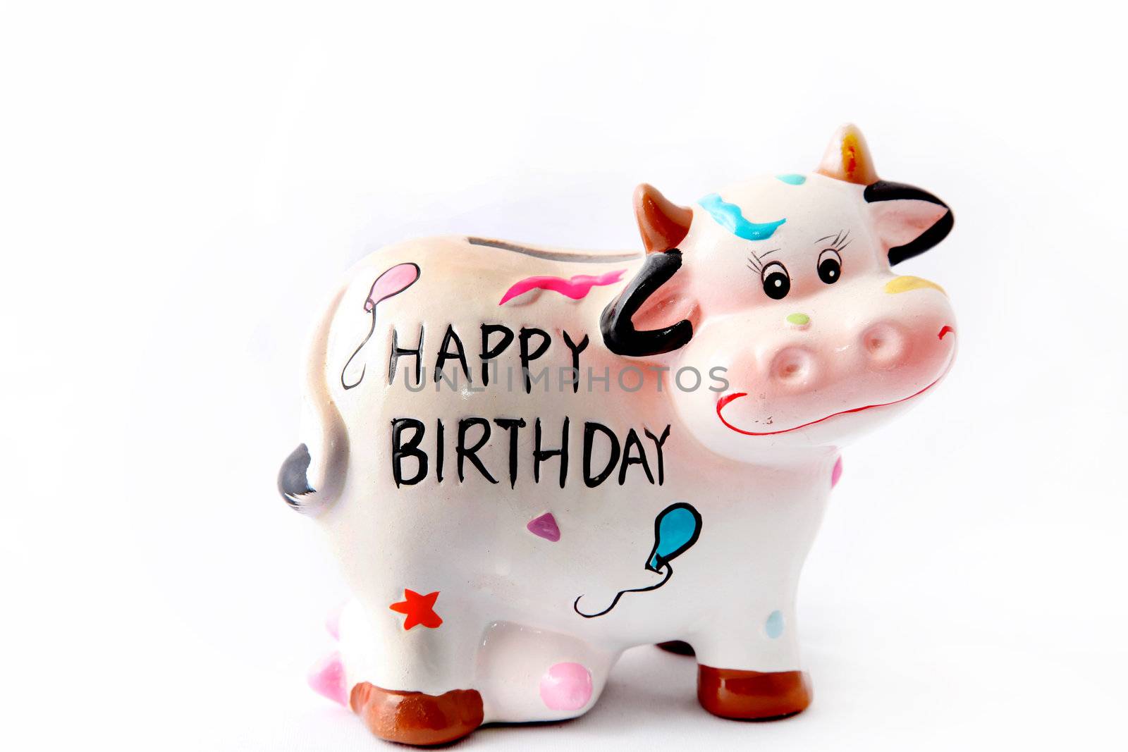 a cheerful brindled cow with the slogan "Happy Birthday" on his stomach