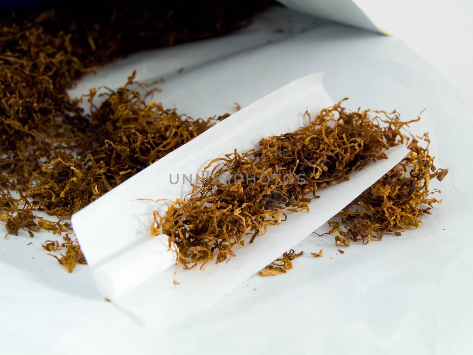 Hand Rolling Tobacco and Hand Rolled Cagarettes on White Background