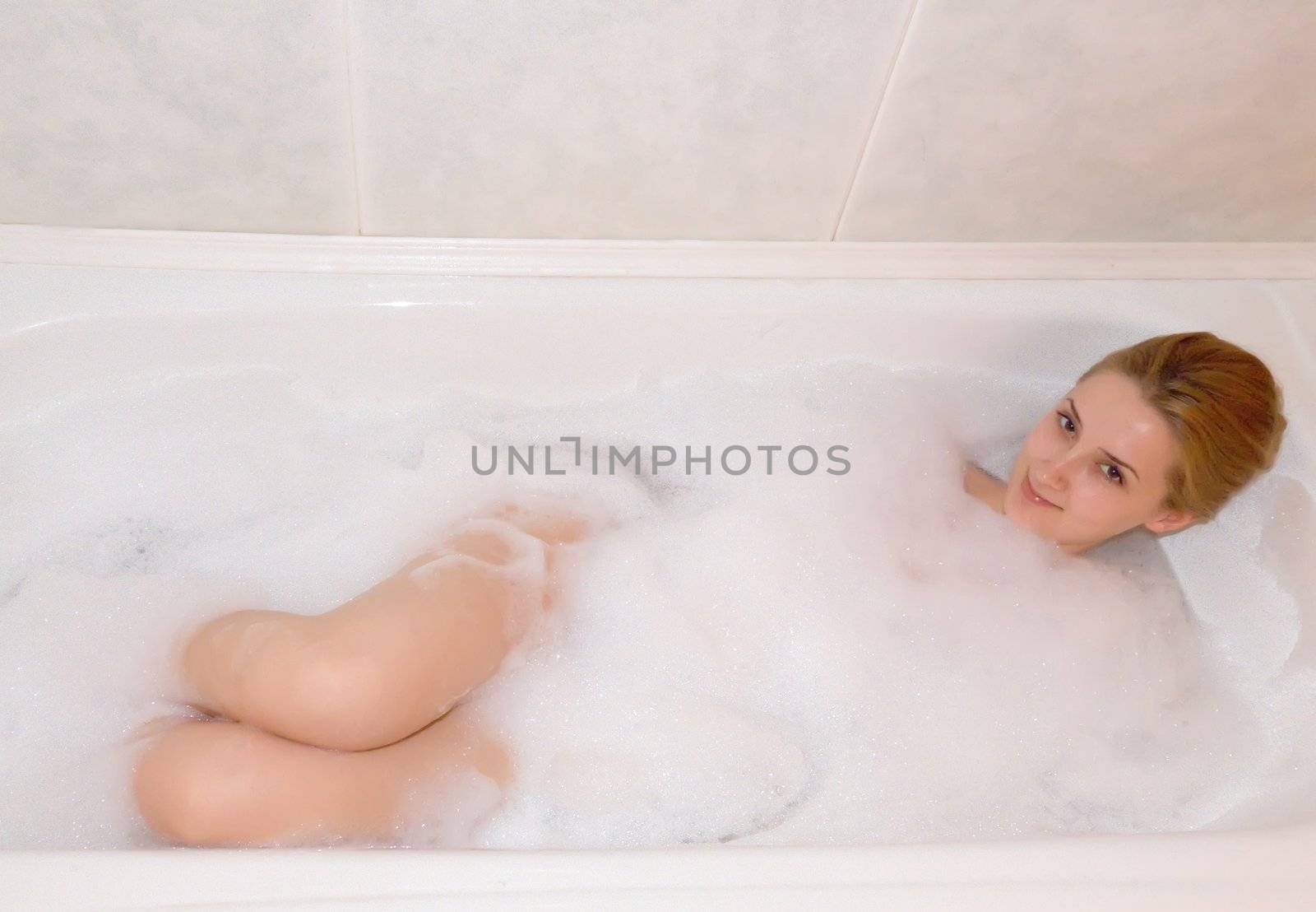 young beautiful girl in a bath with shower