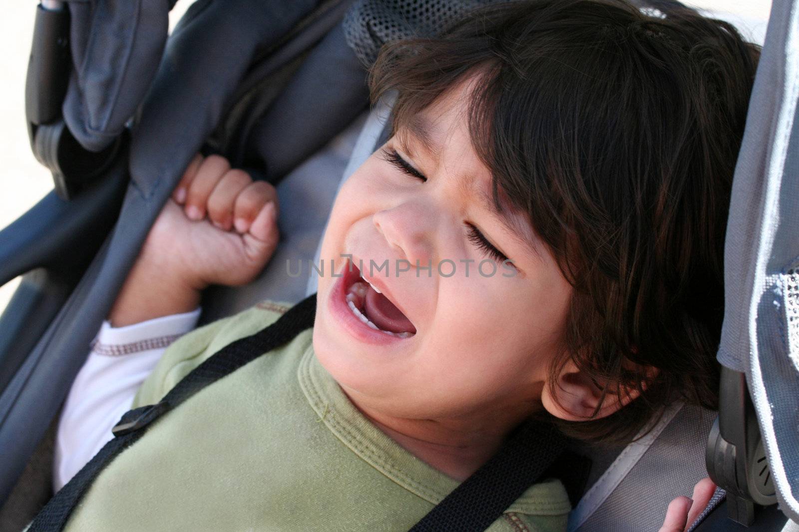 Unhappy toddler crying in stroller