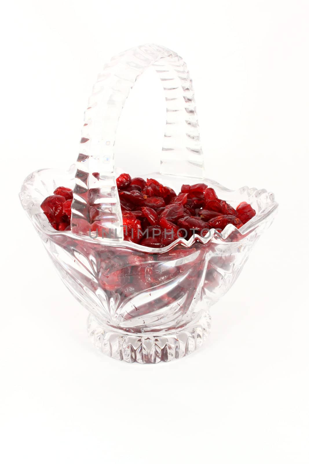 Glass basket full of dried cranberries, isolated on white