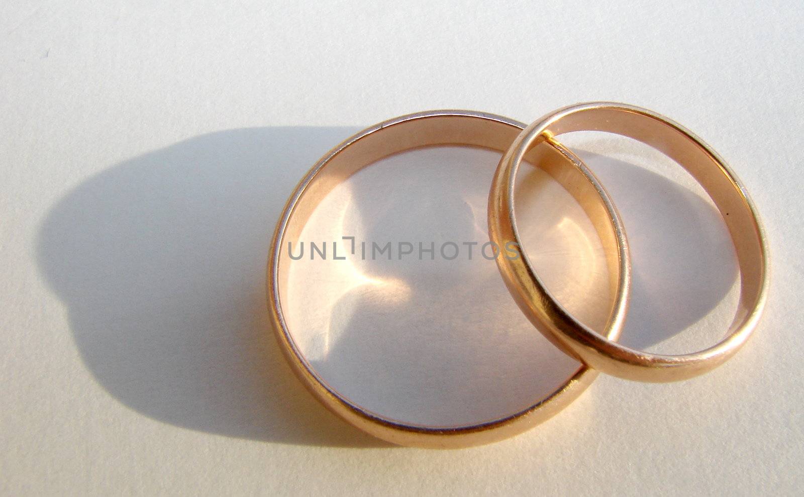 Two wedding gold rings on white background by fotosergio