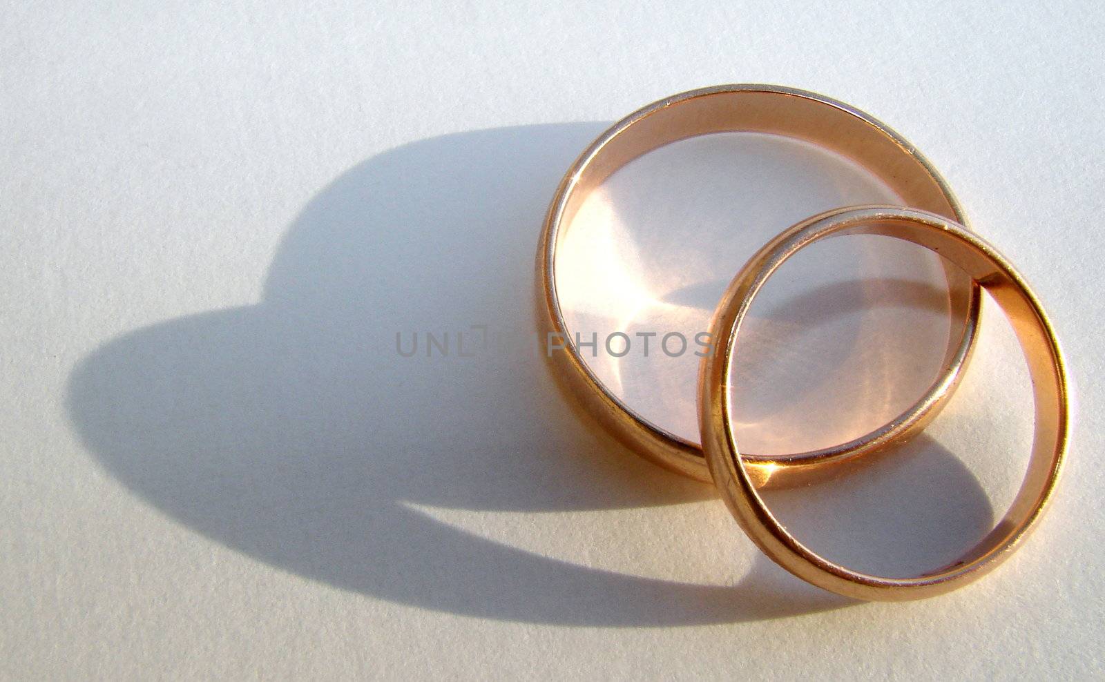 Two wedding gold rings on white background by fotosergio