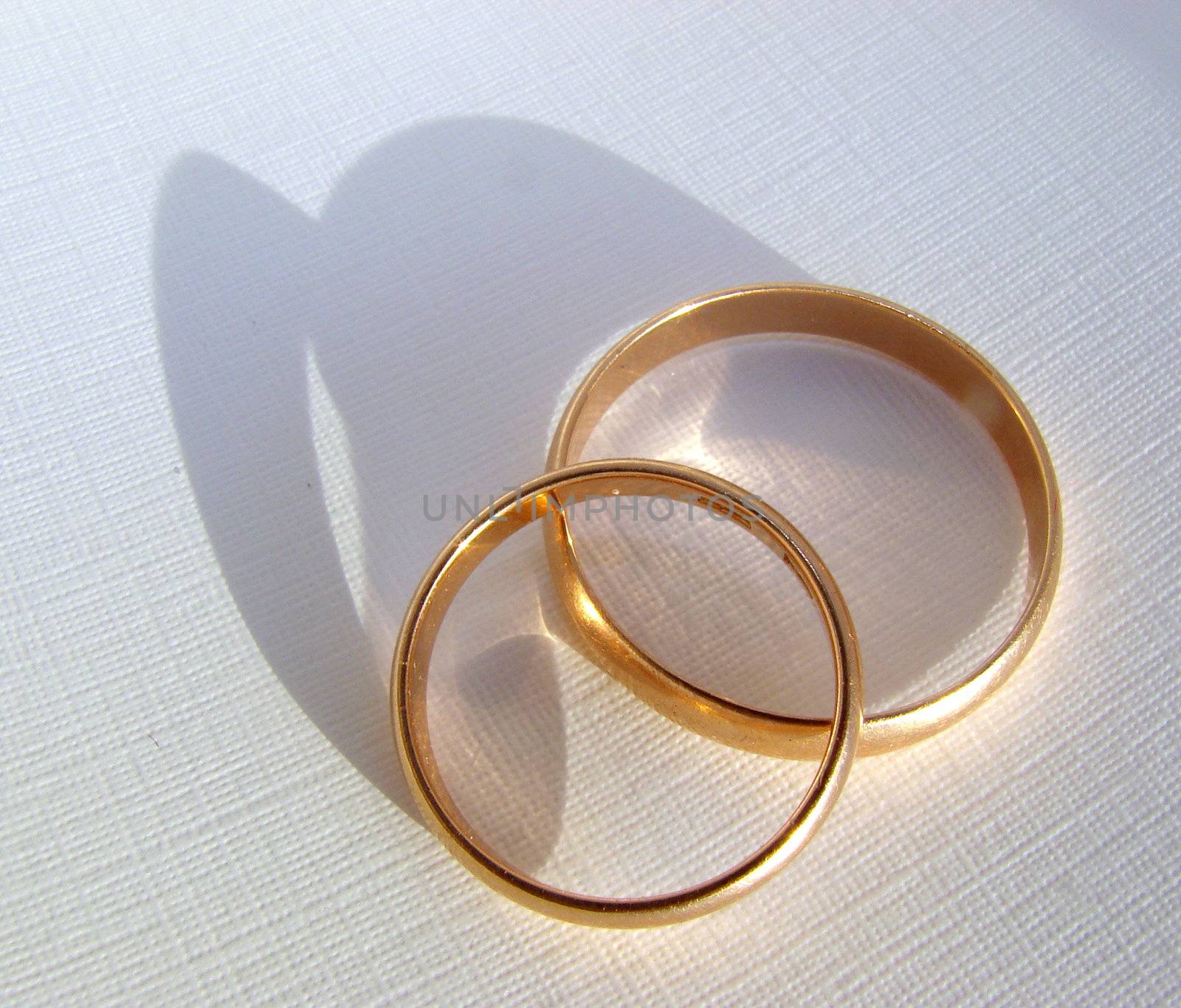 Two wedding gold rings on white background by fotosergio