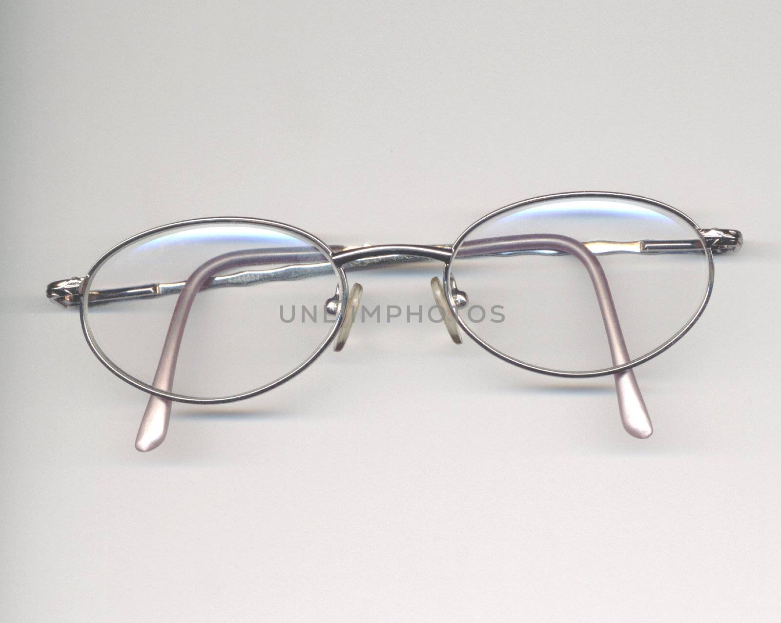 metal rim spectacles over a grey background
