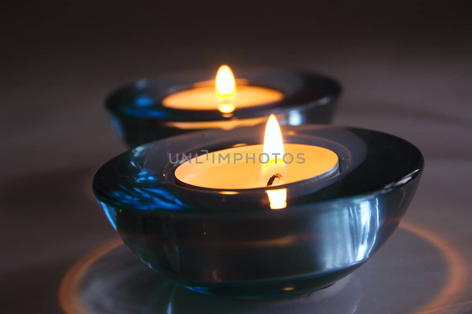 two tealight candles in blue glass holders