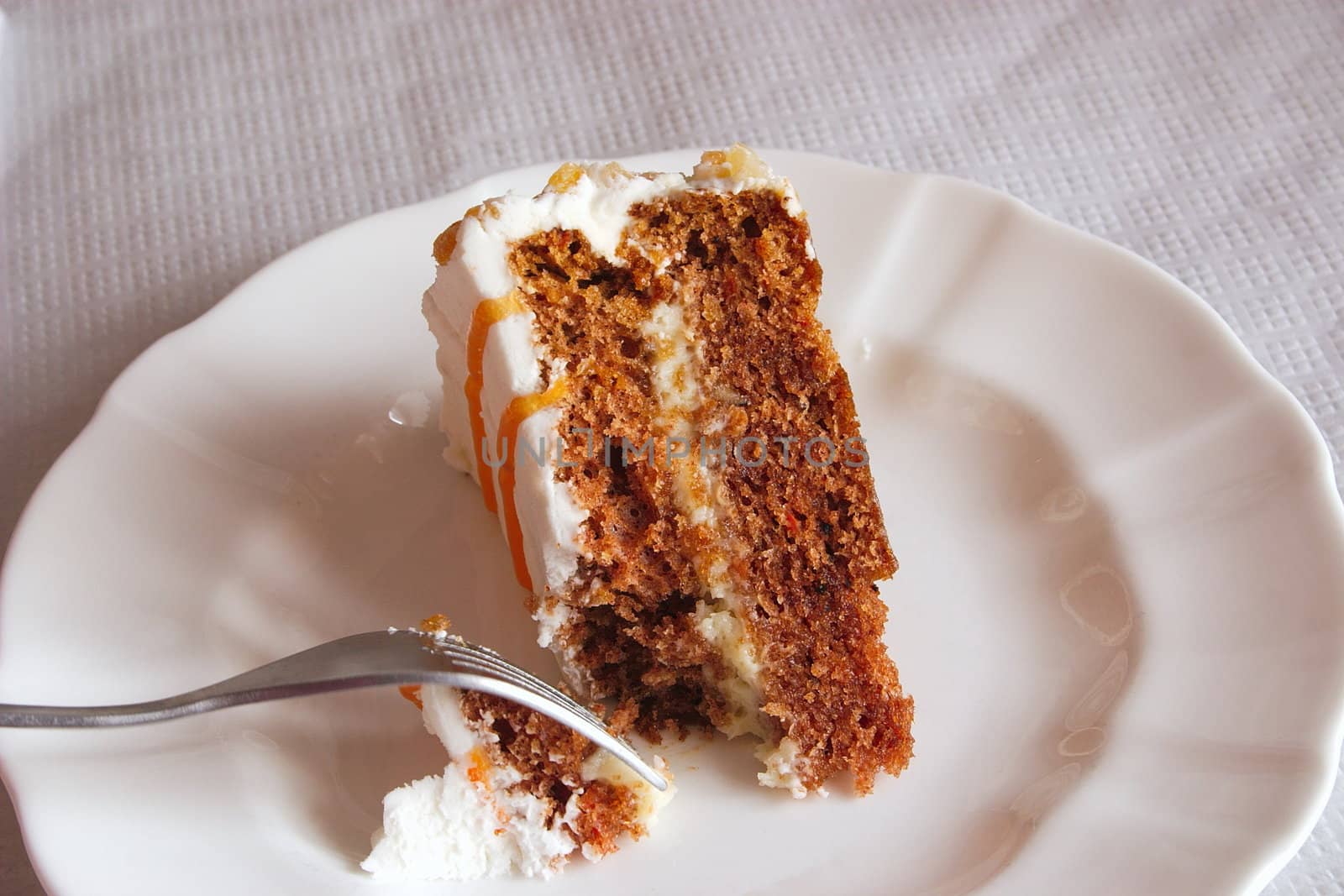 piece of carrot cake being cut with a fork