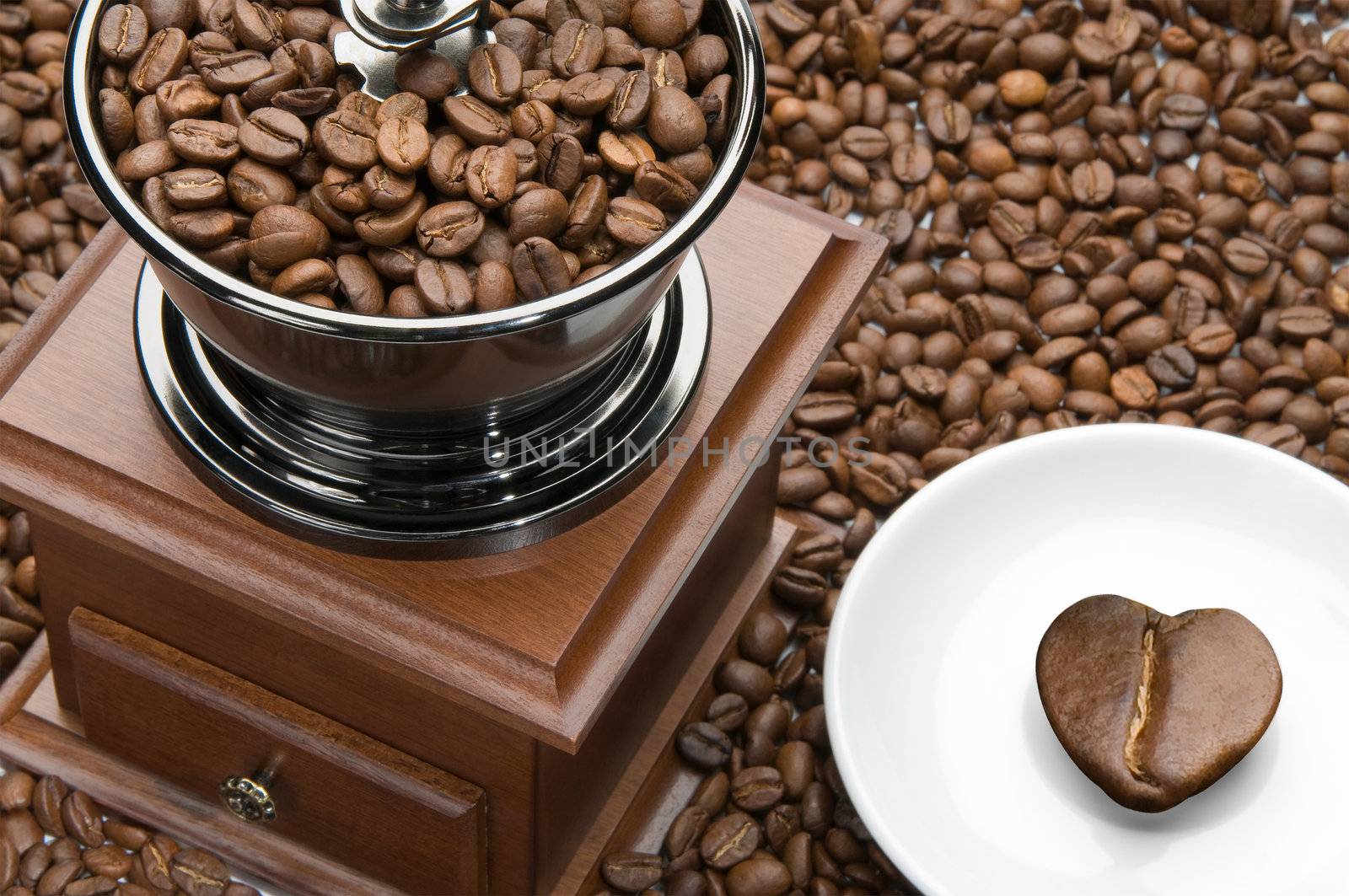 Old coffee grinder and heart on a saucer by zeffss