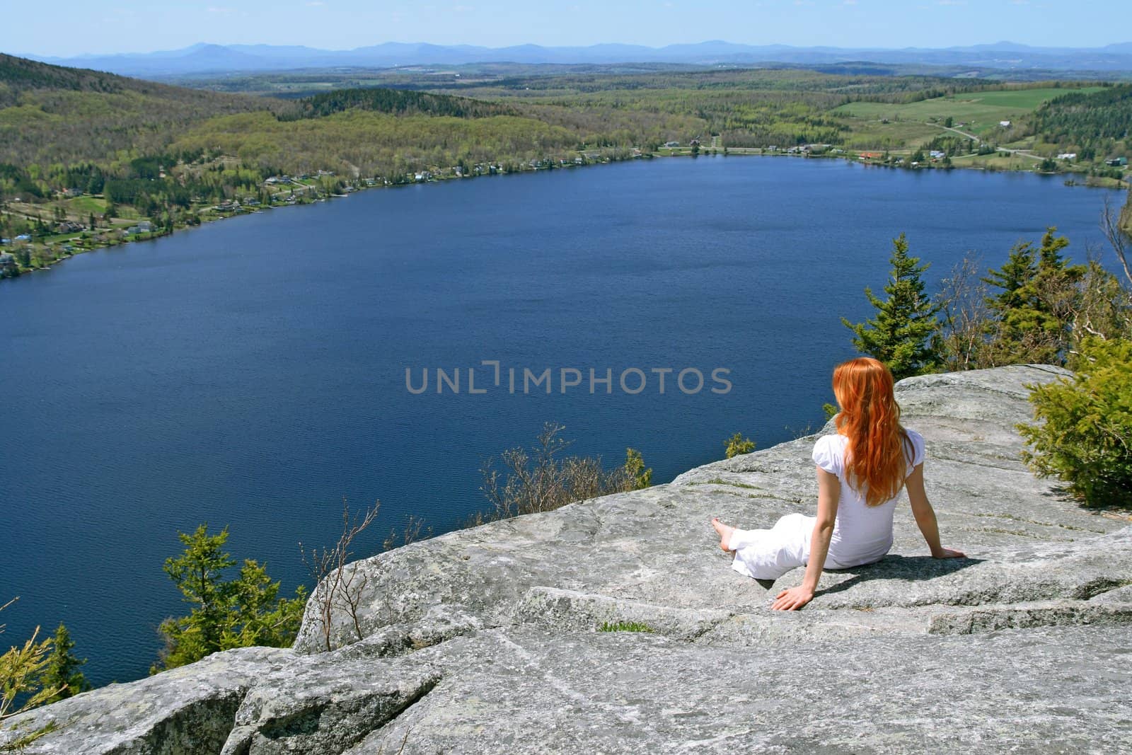 Young woman enjoying the view over lake from the mountain.
