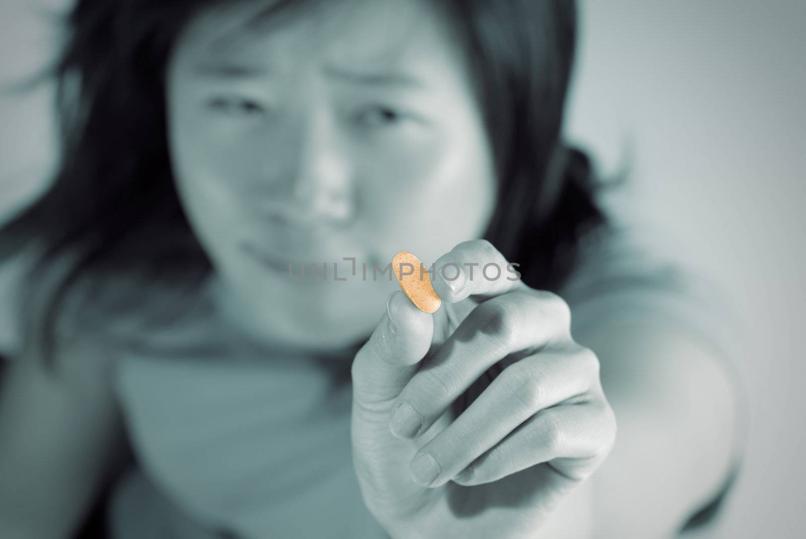 Woman ill holding tablet with ache expression.