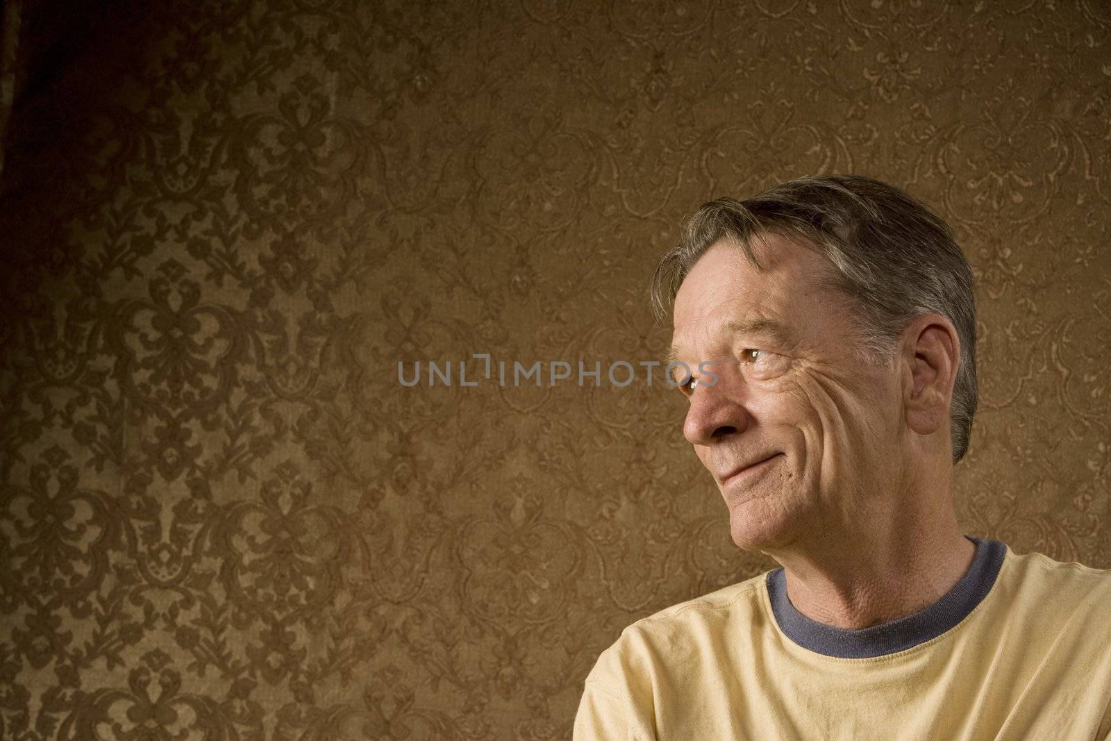 Senior Man Against a Gold Background Looking Left