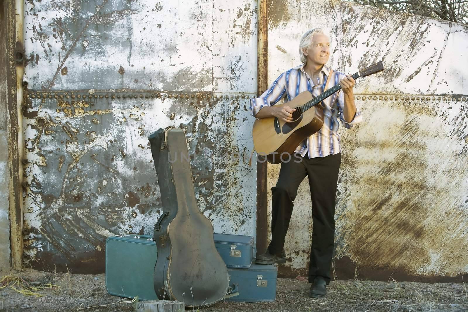 Handsome man playing an old acoustic guitar