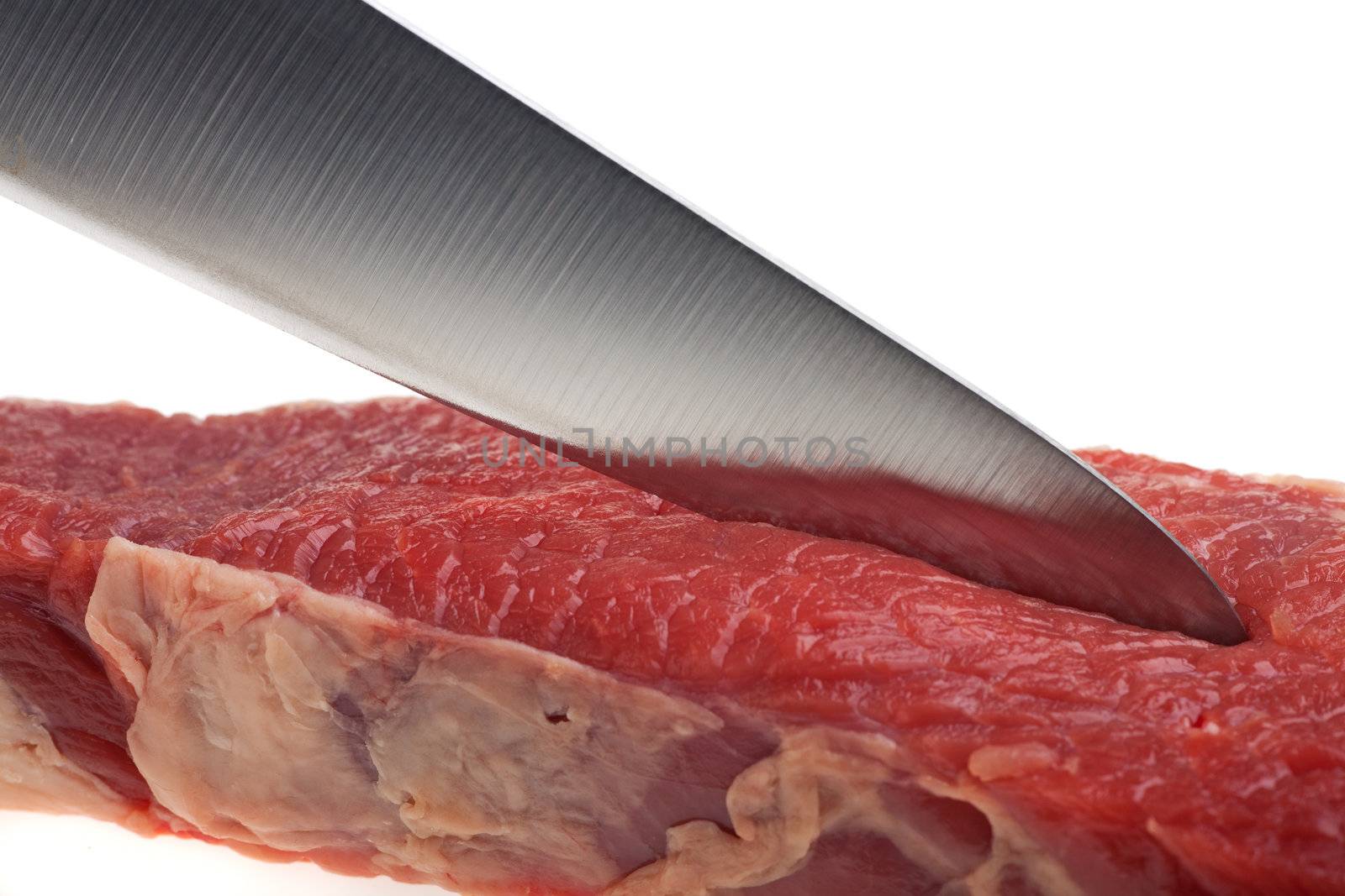 kitchen knife cutting through a raw steak