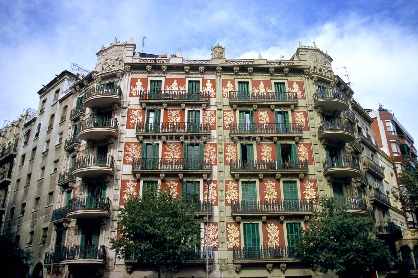 An ornate apartment building stands proudly on a city street in Barcelona, Spain.