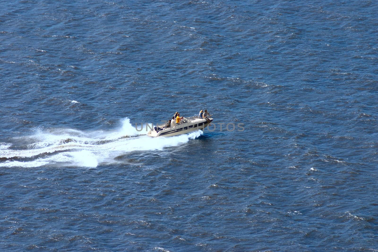 Boat on a water smooth surface removed in the solar afternoon