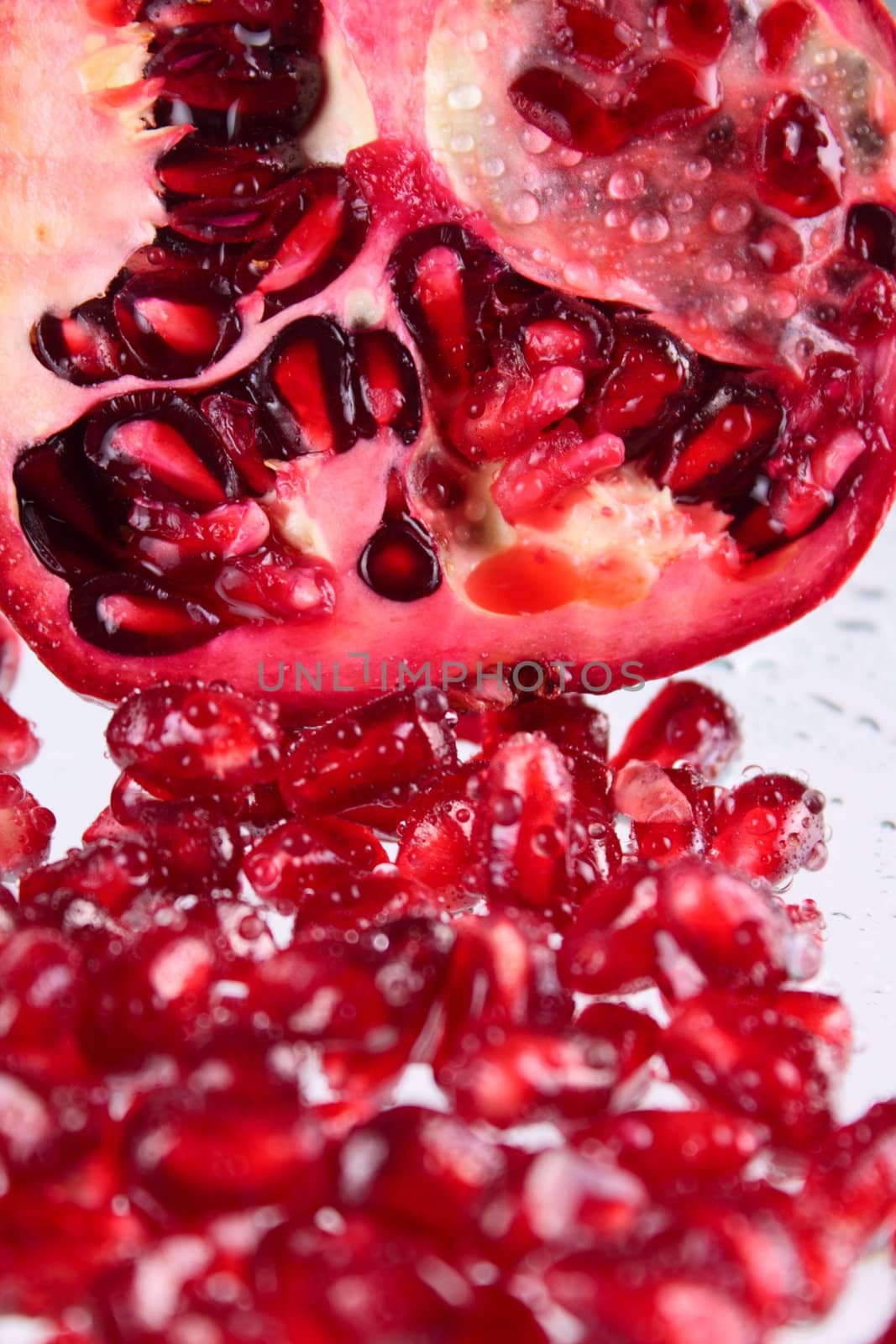 Pomegranate grains removed close up against its part