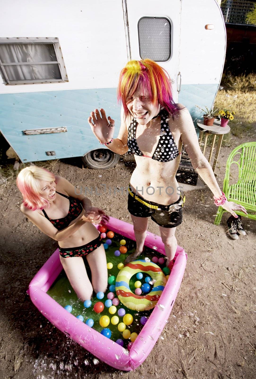 Colorful young women splashing in an inflatable play pool