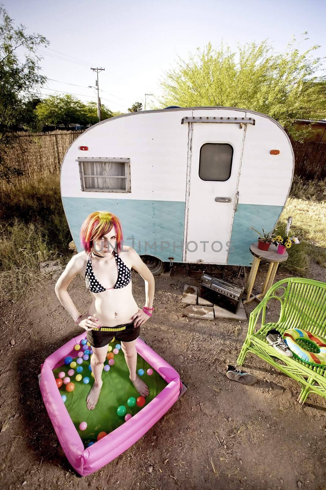 Woman standing in a play pool outside a trailer