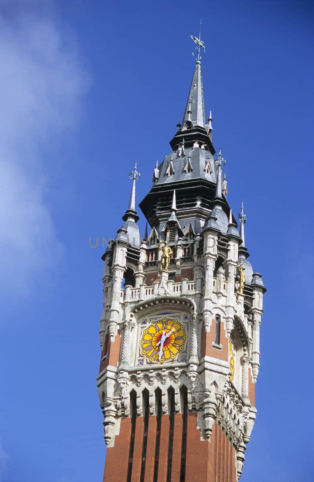 Detail of the colourful clock tower of the town hall building in Calais, France.