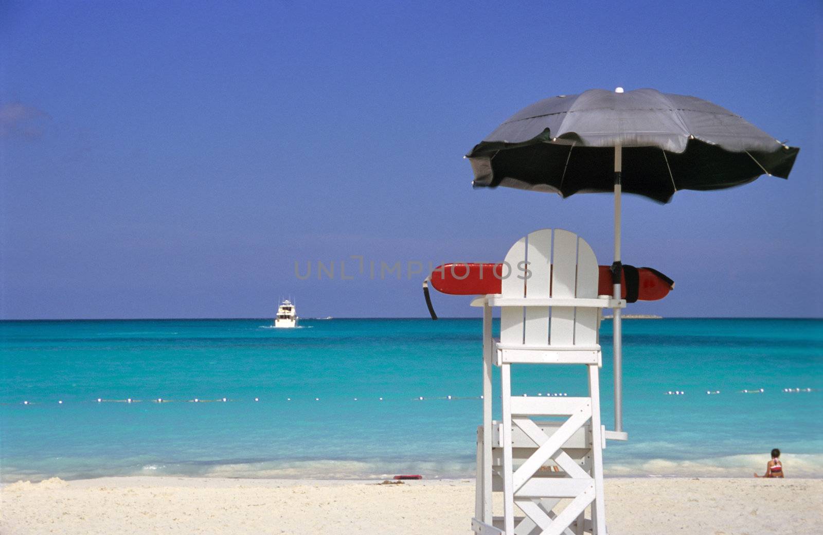 An empty lifeguard chair overlooks rough waters in the Bahamas. 