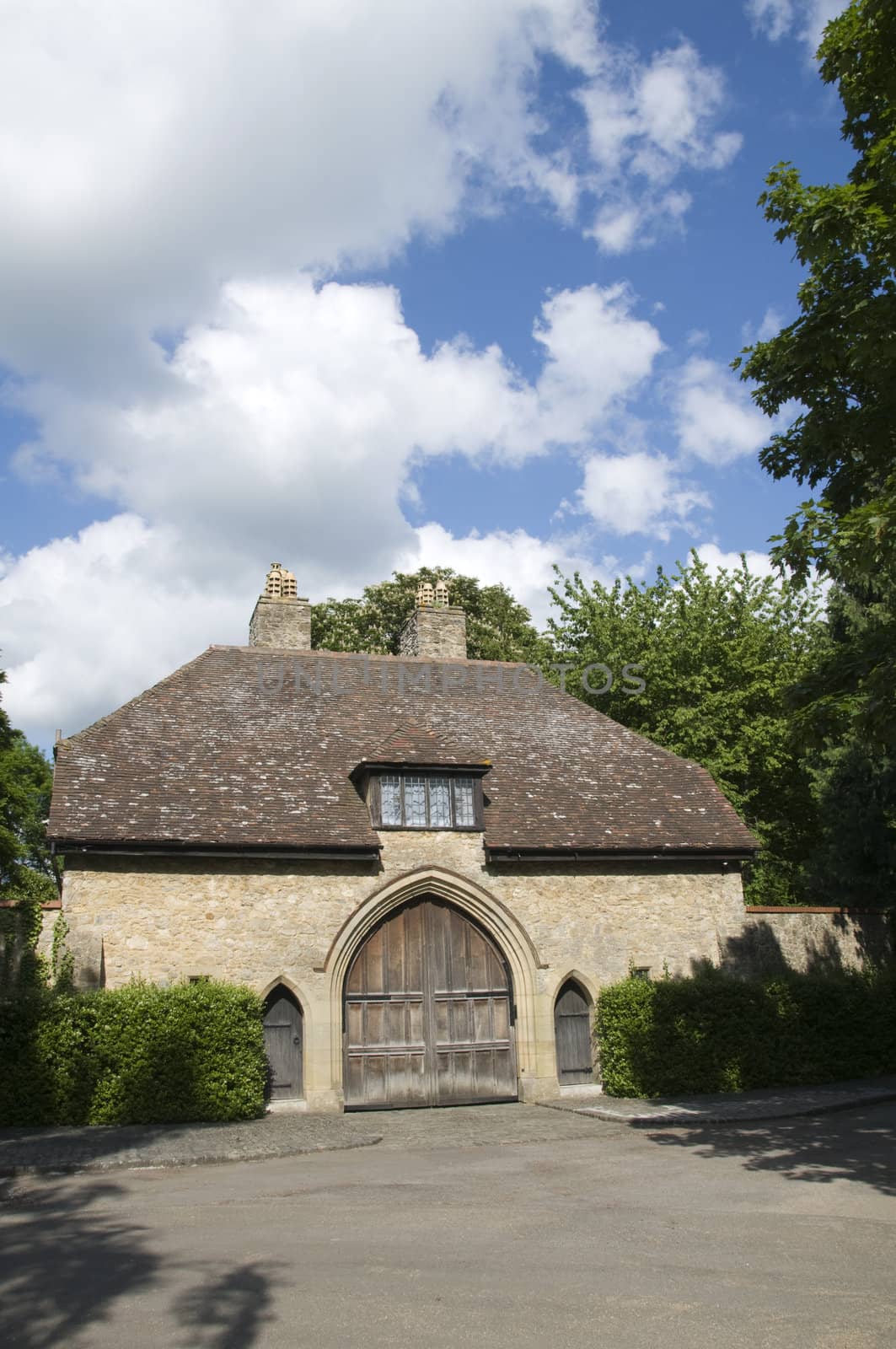 A medieval gate house with a n arched wooden door