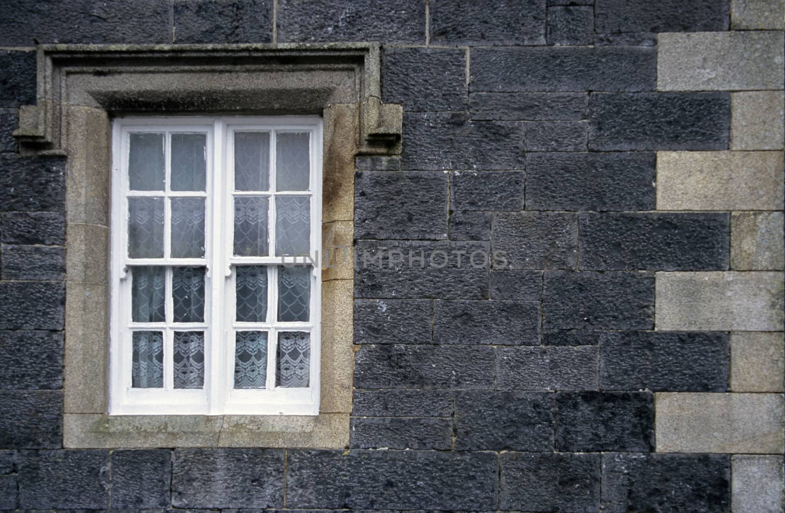 Window with lace curtains at a train station in rural Ireland