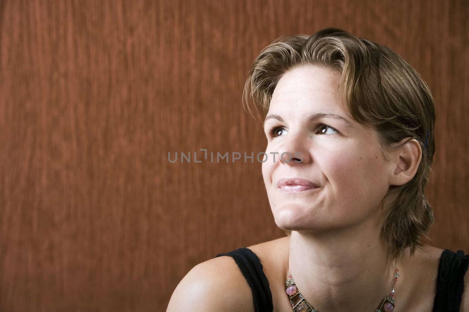 Woman wering a necklace looking up to the left