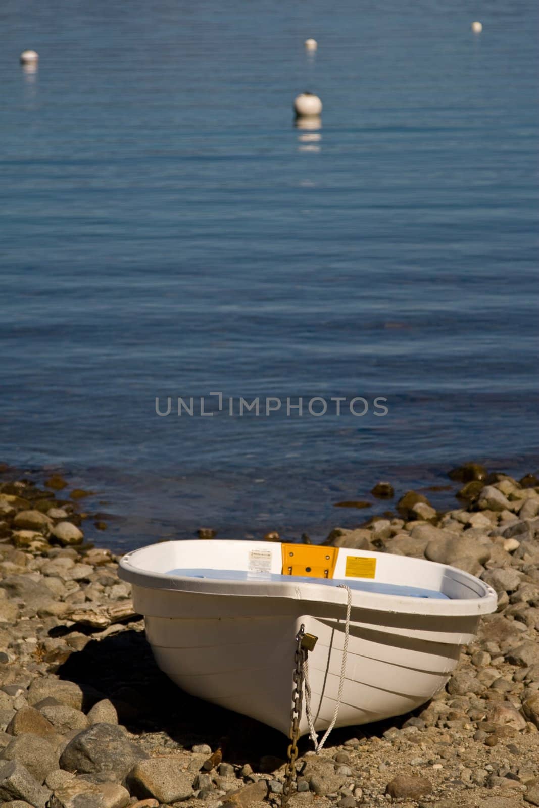 Single plastic boat beached on rocky beach