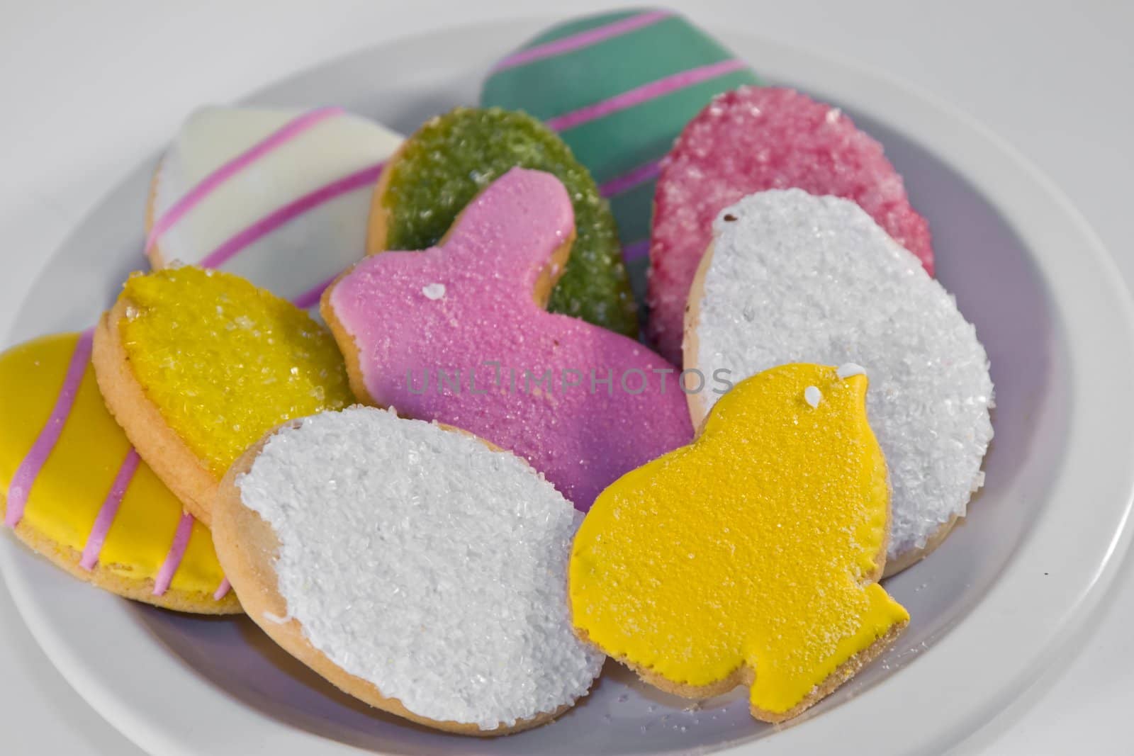 Plateful of iced Easter cookies against white background