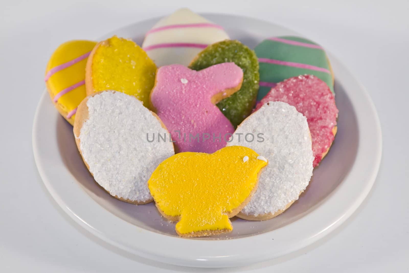 Plateful of iced Easter cookies against white background