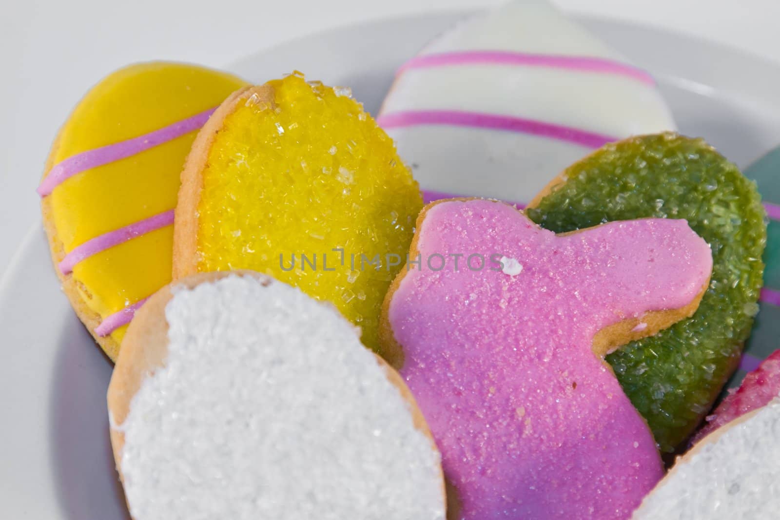 Plateful of iced Easter cookies against white background