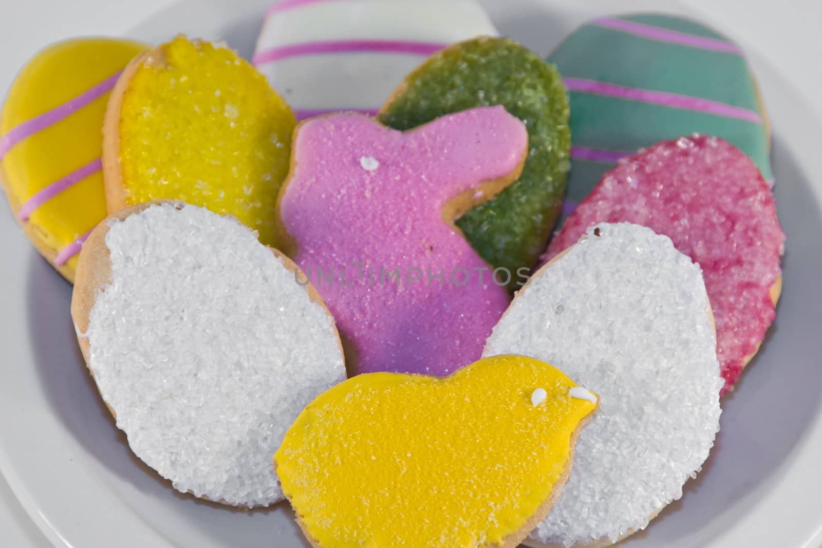 Plateful of iced Easter cookies against white background