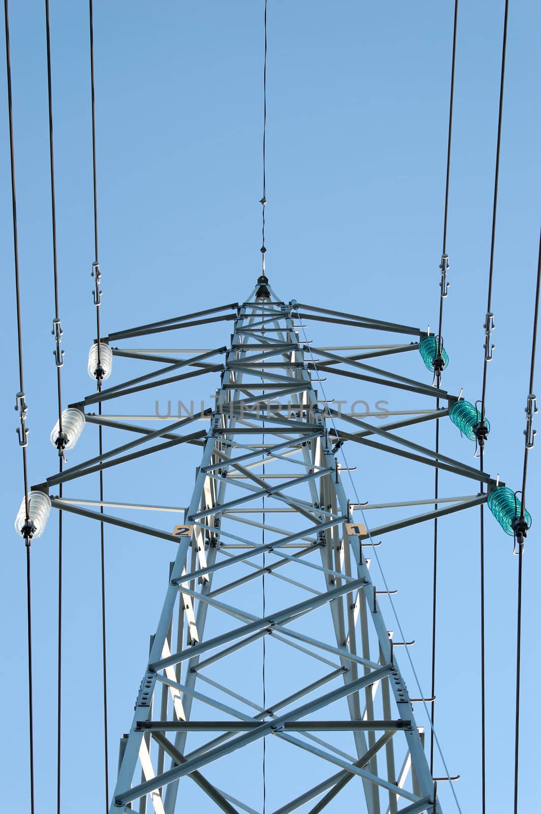 A complete power mast with six fixtures and power lines, seen from a low angle
