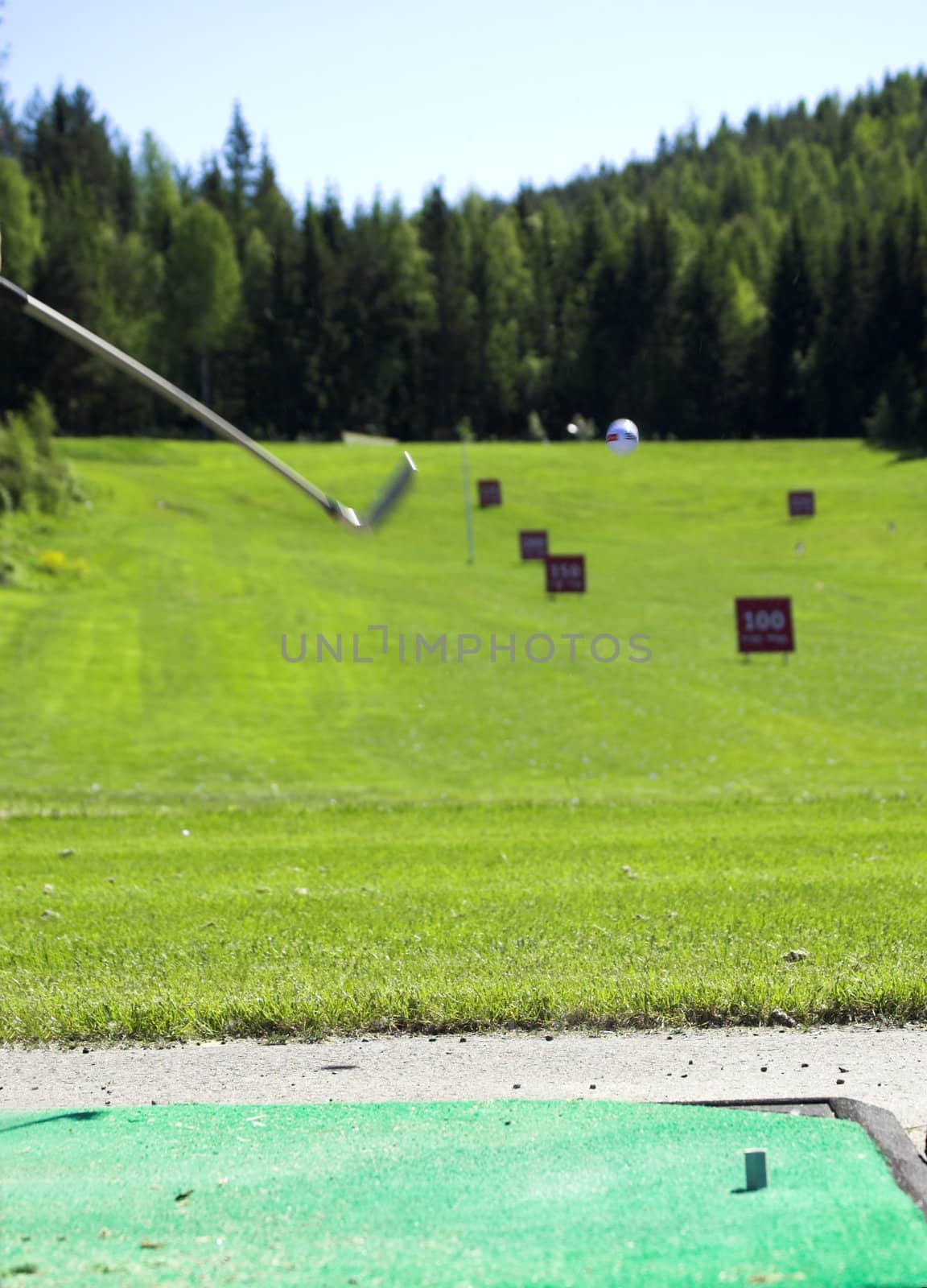 A golf ball and club in action.
