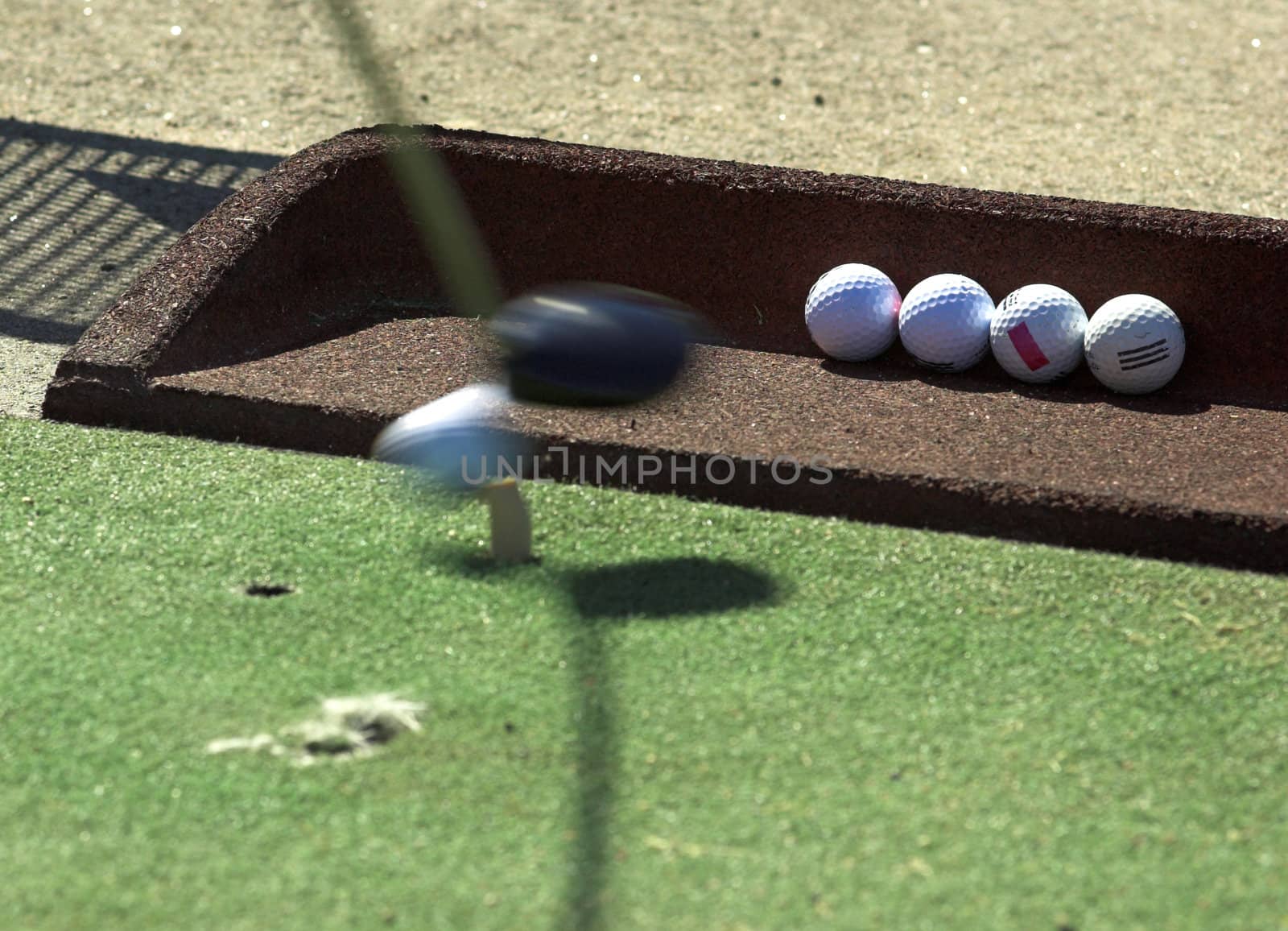 An golf ball just being hit by the club
