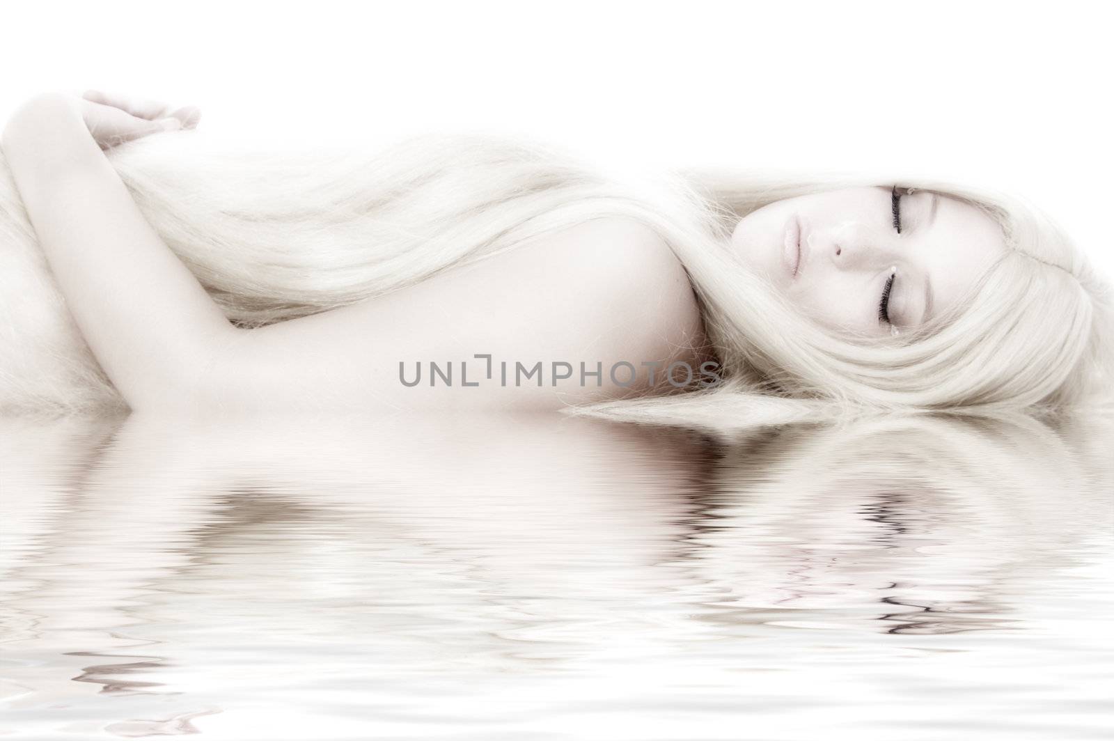 Beautiful blond model in the studio lying down like a princess