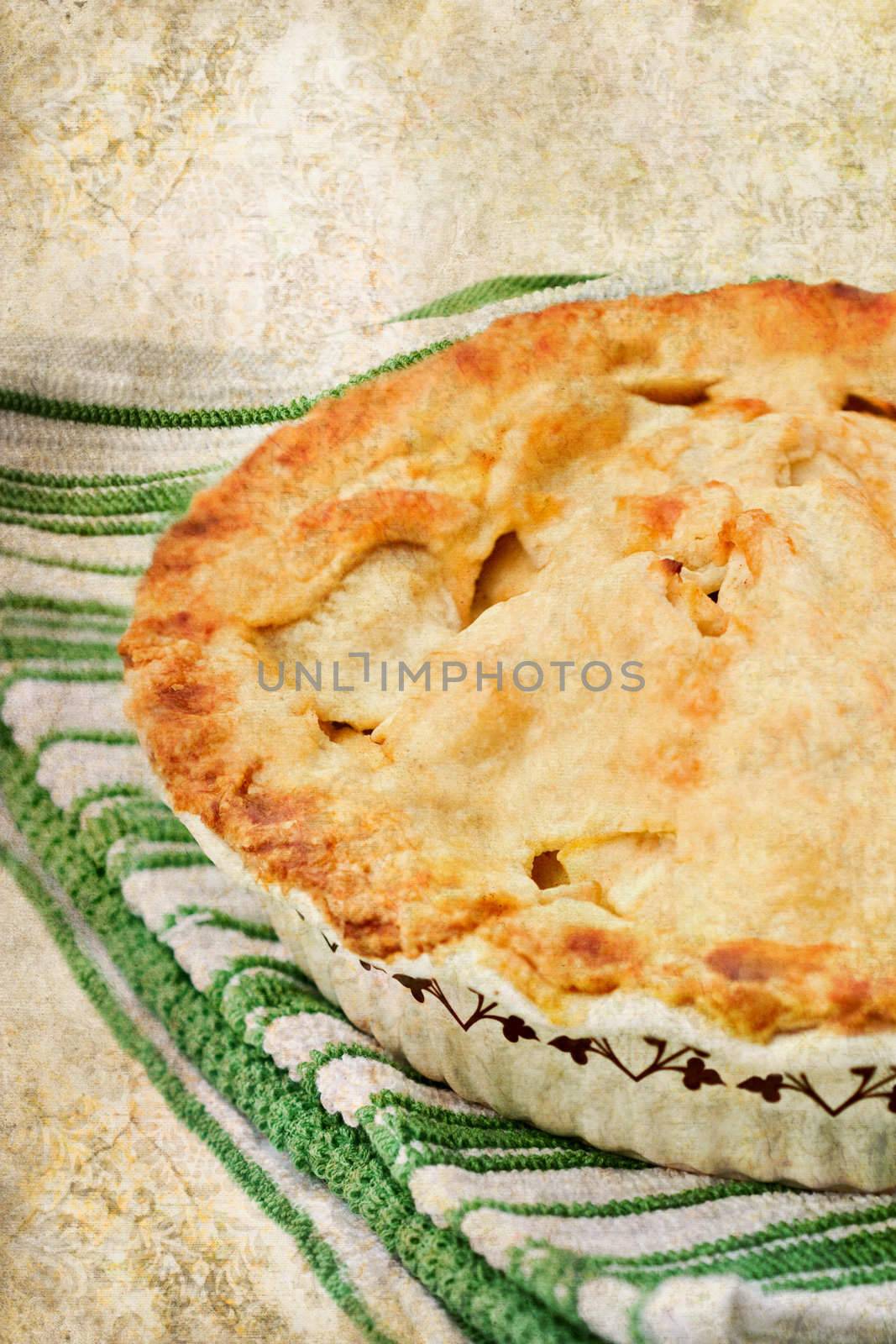 Photo based illustration of an apple pie with a golden buttery crust. 