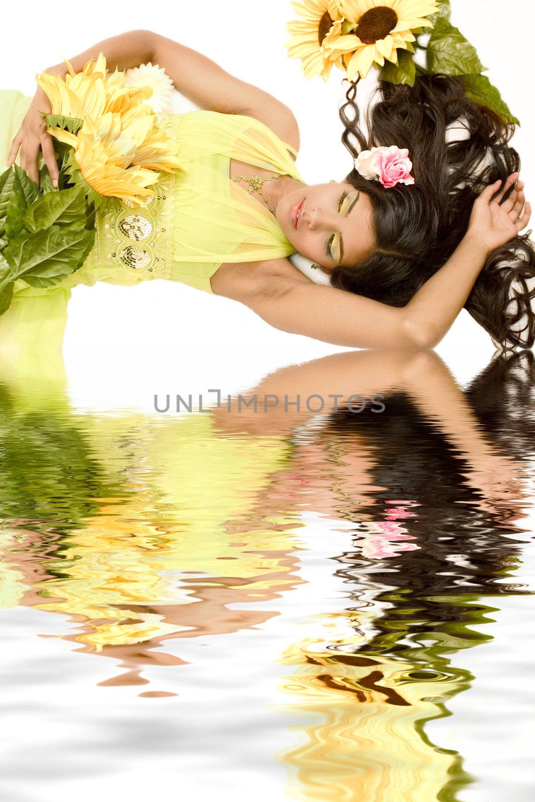 Studio portrait of an Indian  Indonesian beauty model lying on the floor with yellow flowers