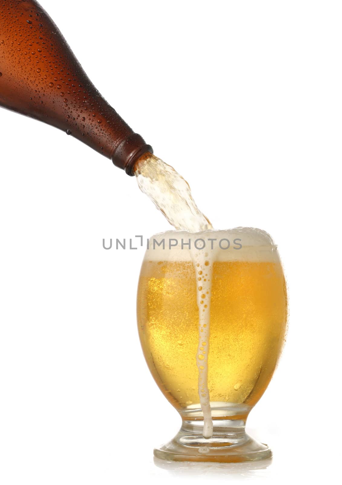 Pouring cold beer into glass isolated on white