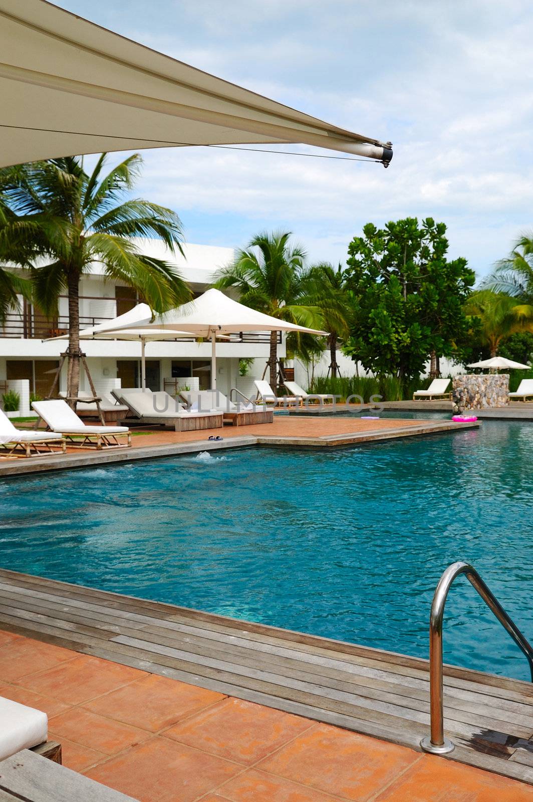 White trestle-beds and umbrellas near the resort's pool