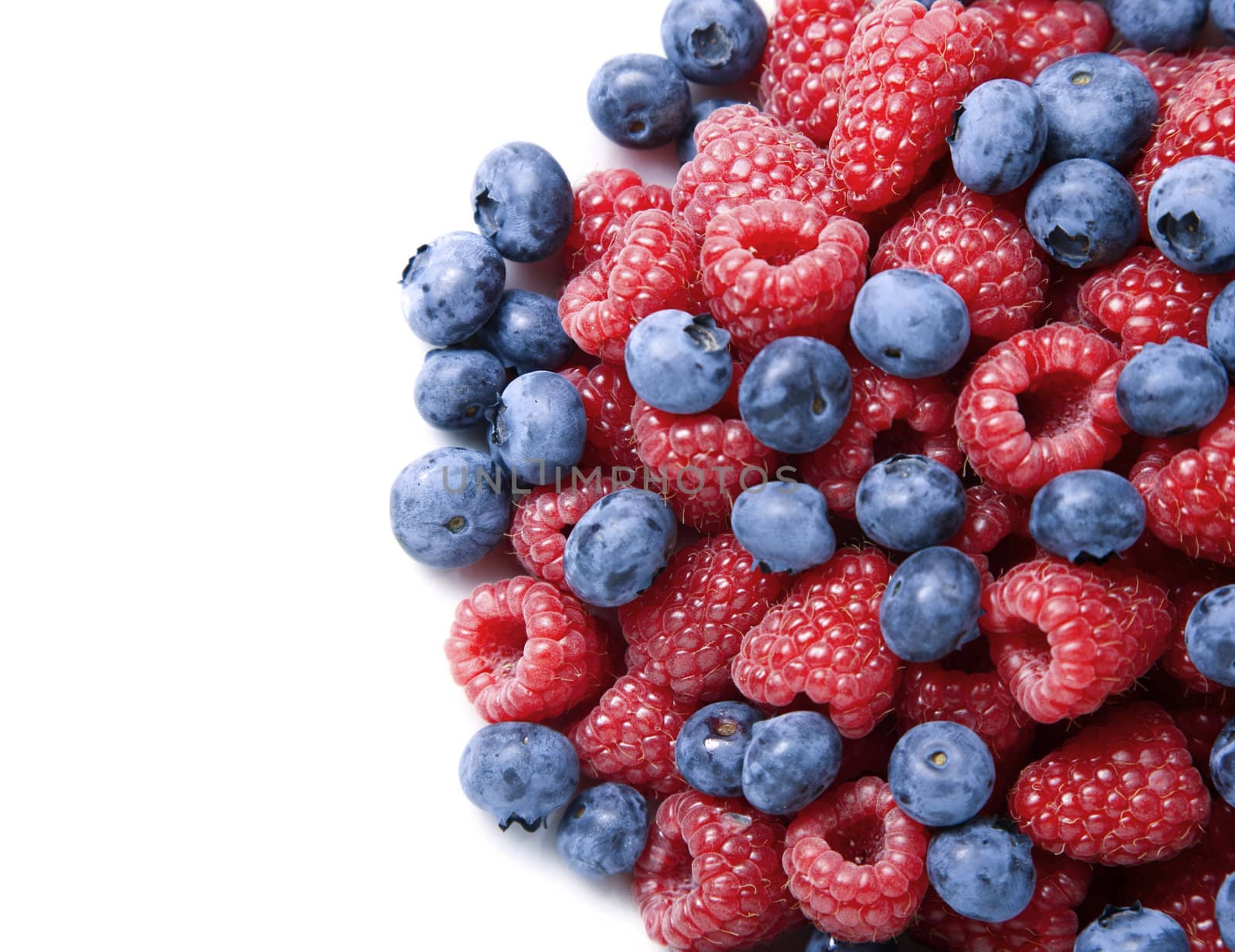 Blueberries and raspberries over white background with copy space