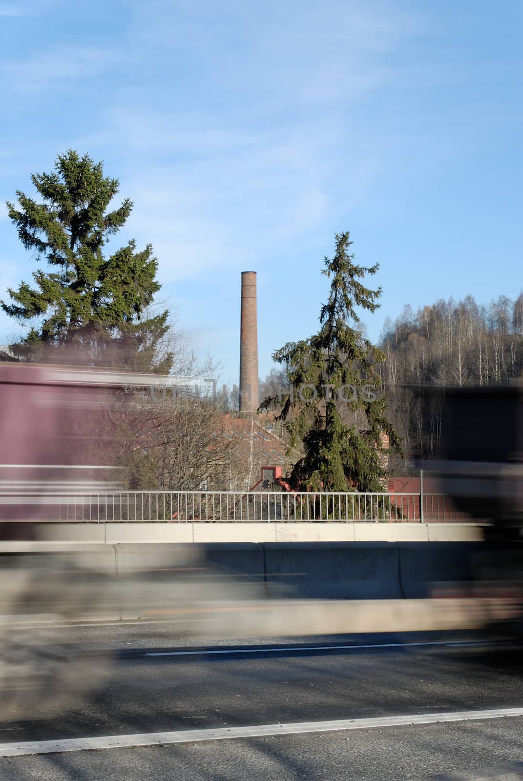 A truck with a hanger zooming by on a highway, framing an old factory chimney. Shot at Nydalen, Oslo, Norway
