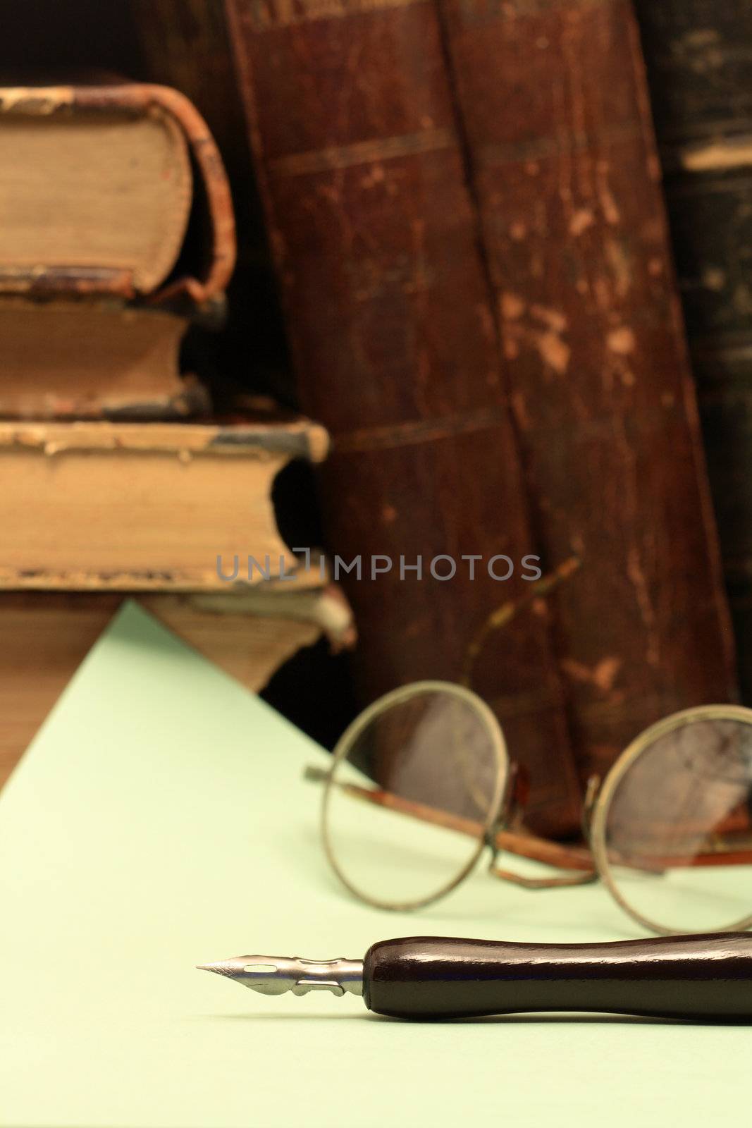 Vintage still life with old fountain pen on background with paper sheet and books