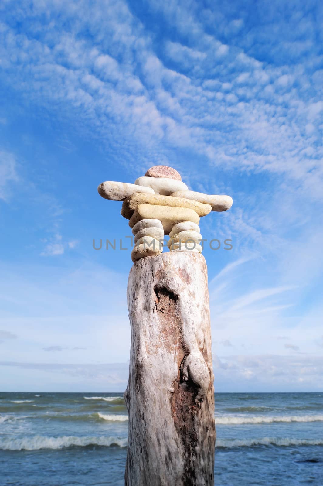 Pebbles in the form of figurines on top of a wooden block